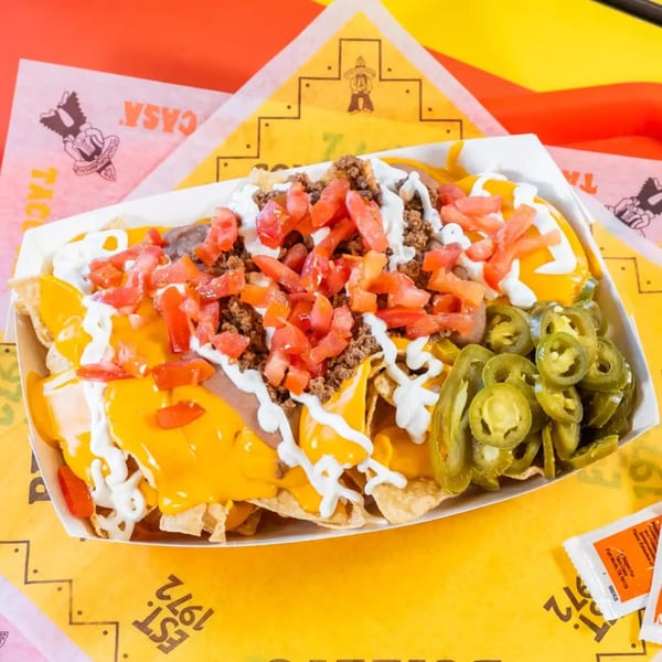 Taco Casa nachos with cheese, ground beef, tomatoes, sour cream, and jalapeños.