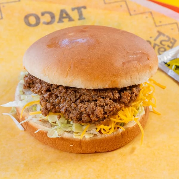 A sloppy joe sandwich with ground beef, shredded lettuce, and cheese on a bun.